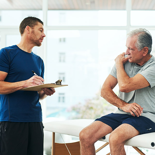 physiotherapist performing consultation with a senior patient